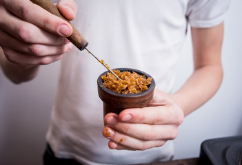 Cooking hookah in the bar. Cutting tobacco into a bowl. Restaurant, hookah bar, smoking cafe.