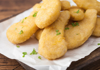 Buttered chicken nuggets on chopping board on wooden background. Macro
