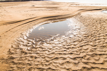 river bank with sand dunes seen because of shallow water