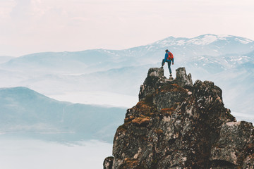 Traveler man climbing on mountain top adventure travel extreme healthy lifestyle vacations hiking outdoor success achievement brave hiker on the edge - obrazy, fototapety, plakaty