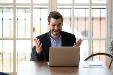 Excited businessman reading good message, celebrating success
