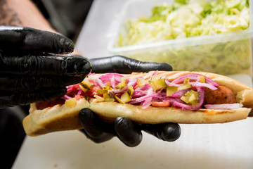 The chef cooking hot dog on a grill. Restaurant.