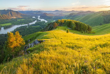 Obraz premium Tourism in Altay, Russia. View of the valley and the Katun River from the mountain. Spring panoramic view. Green forests and meadows and a beautiful sky.