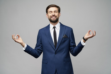 studio photo of meditative young handsome stylish businessman wearing suit