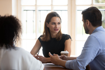 Confident businesswoman team leader holding briefing with diverse colleagues