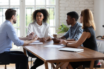 Diverse employees team discussing project strategy at corporate briefing