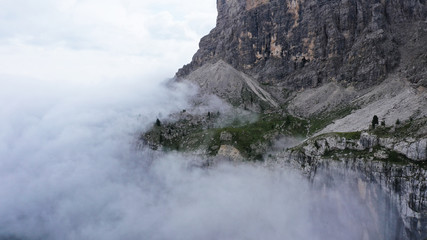 Aerial view of Dolomites Alpine mountains in fog and low clouds. South Tyrol, Italy.