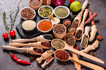 Spices and herbs over black stone background. Top view with free space for menu or recipes