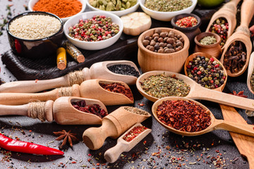 Spices and herbs over black stone background. Top view with free space for menu or recipes