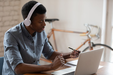 African American businessman wearing headset using laptop, working online