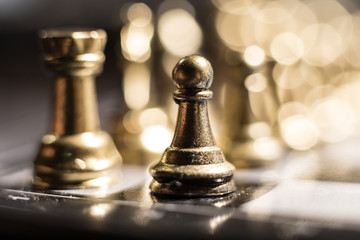 Chess figures on a dark background with smoke and fog. Selective focus