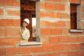 Fototapeta na wymiar Professional engineer architect worker with protective helmet at house building construction site background