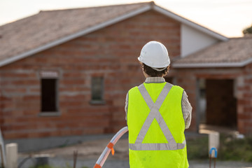 Professional engineer architect worker with protective helmet at house building construction site background