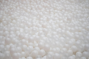 Many white plastic balls in ball pit for kid