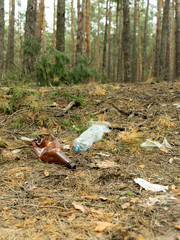 Empty plastic bottle in the form of garbage in the forest thrown by man. The concept of environmental pollution by human life products.