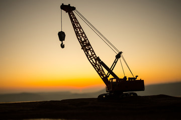 Abstract Industrial background with construction crane silhouette over amazing sunset sky. Tower...