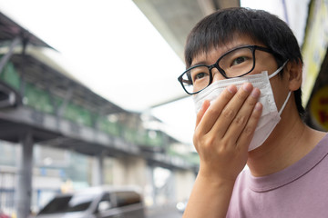 HandsomeMan wearing face mask protect filter against air pollution (PM2.5) or wear N95 mask. protect pollution, anti smog and viruses, Air pollution caused health problem. Global warming concept.