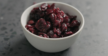 closeup dried cranberry in white bowl on terrazzo countertop