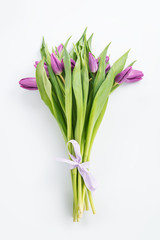 Bouquet of purple tulips on white top view