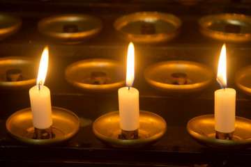 Fototapeta na wymiar three candles in the dark