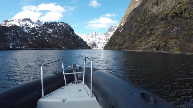Riding an airboat through the trollfjord at the Lofoten Islands in First Person View with surrounding snow covered mountains.