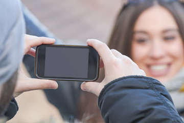 Couple using cellphone in cold winter times outdoors.