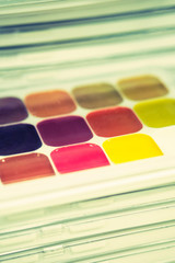 Stack of packages with different colors - watercolor for the artist. Toned. Vertical.