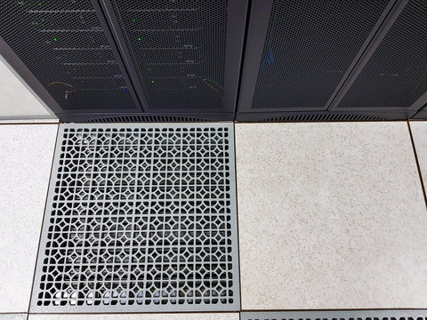 Raise floor and cool air ventilation panel in front of network rack equipment to keep all hardware working with the right temperature. Interior design of Telecom grade data center. Technology concept