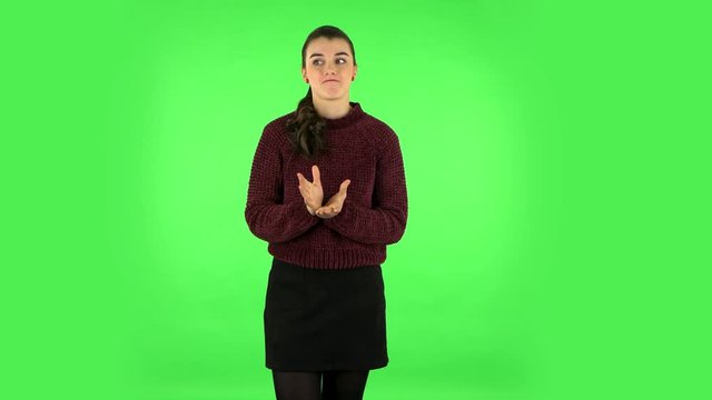 Woman throwing up hands expressing she is innocent, saying oops she doesn't know what's going. Green screen