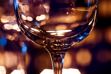 Wine and martini glasses in shelf above a bar rack in restaurant. Empty clean glasses in bar.