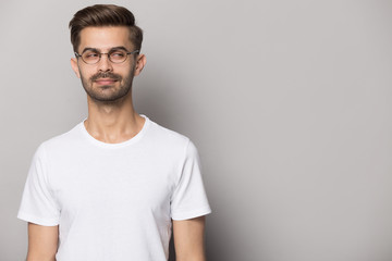 Fototapeta premium Podejrzany młody człowiek w okularach, patrząc z boku na miejsce.