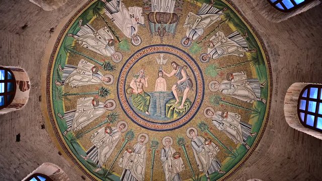 Ravenna, Italy, December 2019. Arian Baptistery. Fixed shot of the vault with the baptism of Christ. Around you can see the windows and the walls with exposed bricks.