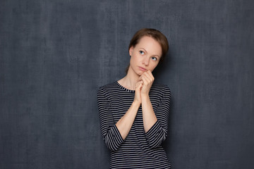 Portrait of focused pensive girl being deep in thoughts
