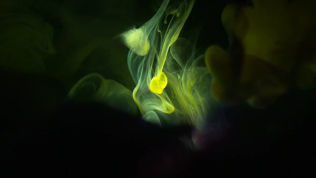 Real Shot Color Paint Drops In Water In Slow Motion. Ink Swirling. Color Ink Dropped In Water On Black Background. Cloud Of Silky Ink In Water Isolated.