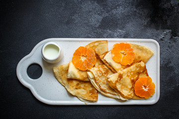  crepes with citrus, jam and berries (thin pancakes, mandarin, blueberry) menu concept. background. top view. copy space