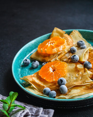  crepes with citrus, jam and berries (thin pancakes, mandarin, blueberry) menu concept. background. top view. copy space