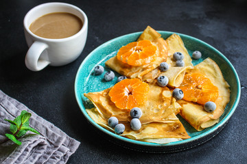  crepes with citrus, jam and berries (thin pancakes, mandarin, blueberry) menu concept. background. top view. copy space