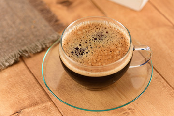 Coffee in a glass cup on a wooden table