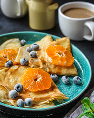  crepes with citrus, jam and berries (thin pancakes, mandarin, blueberry) menu concept. background. top view. copy space