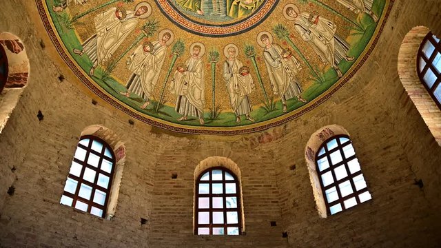 Ravenna, Italy, December 2019. Baptistery of the Aryans. Tilt movement footage towards the magnificent mosaics of the vault. From the red brick walls we move on to the colorful mosaic.