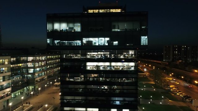 Aerial: Glass Office Building At Night. Captivating View Of A High Building, Office Skyscrapers At Night.