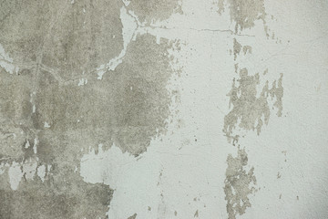 White and Grey old dirty wall with surface peeling shabby cracked damaged  plaster mortar  Cement  textured  background close up
