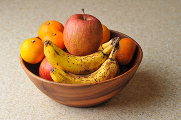 Wooden fruit bowl with apples, oranges, and bananas