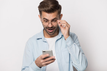 Young shocked man reading email with unbelievable news.