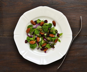 Broccoli salad with red onions, almonds and dried cranberries, top view, copy space