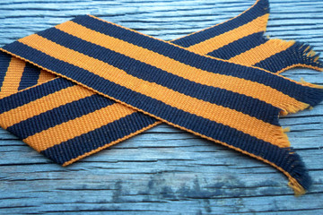 St. George ribbon on a wooden background. Symbol of courage and victory, May 9 and February 23.
