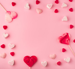 Pink romantic holiday background with with heart-shaped sweet candies. Decorative card for St. Valentine's Day with space for text.