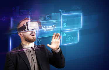 Businessman looking through Virtual Reality glasses with SOFTWARE TESTING inscription, new technology concept