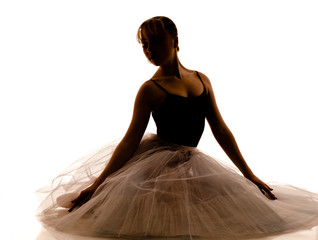 Silhouette of young beautiful ballerina in white tutu and pointe shoes doing dancing pose © YouraPechkin