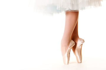 Legs of ballerina woman in white tutu and pointe shoes over white background
